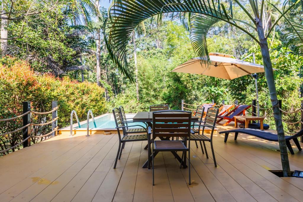 a patio with a table and chairs and an umbrella at Villa Primor madawan Koh Phangan in Wok Tum