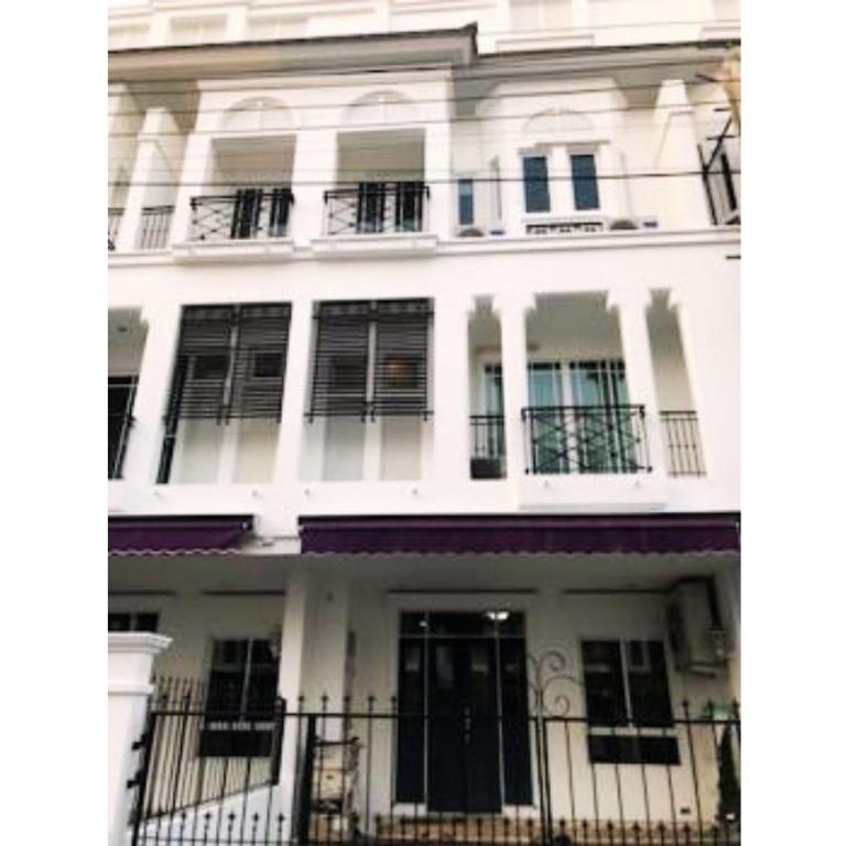 een wit gebouw met zwarte deuren en ramen bij Leon Sukhumvit 62 in Bangkok