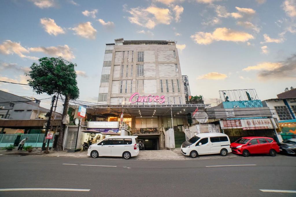 twee witte auto's geparkeerd voor een gebouw bij The Panorama Suites by MHM in Jakarta