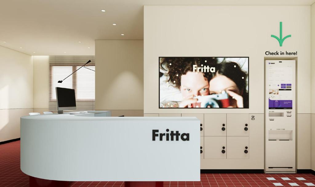 Fritta Hotel في Suwŏn-yŏk: مكتب به فاصل معلق عليه تلفاز