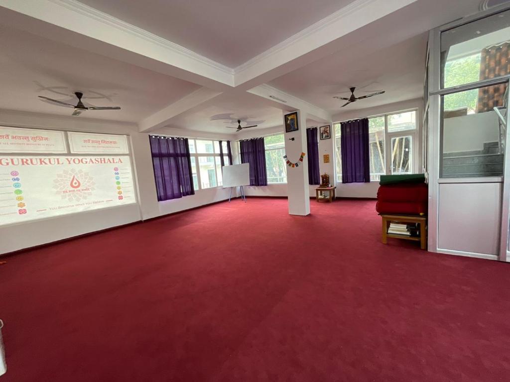 Una gran sala con alfombra roja con una presentación. en Aradhya Gange Residency, en Rishīkesh