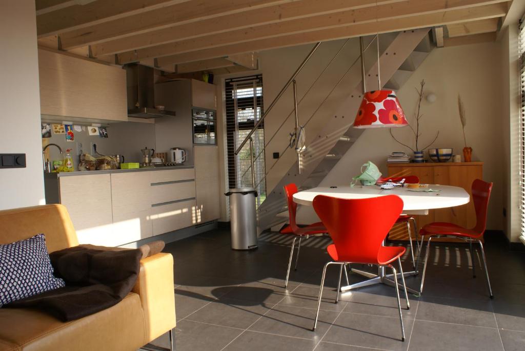 a kitchen and living room with a table and chairs at Bergen Holiday Home in Schoorl