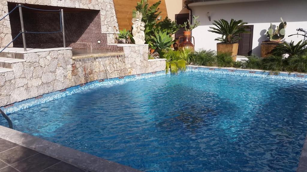 una piscina de agua azul en una casa en Villa Antheus, en Graniti