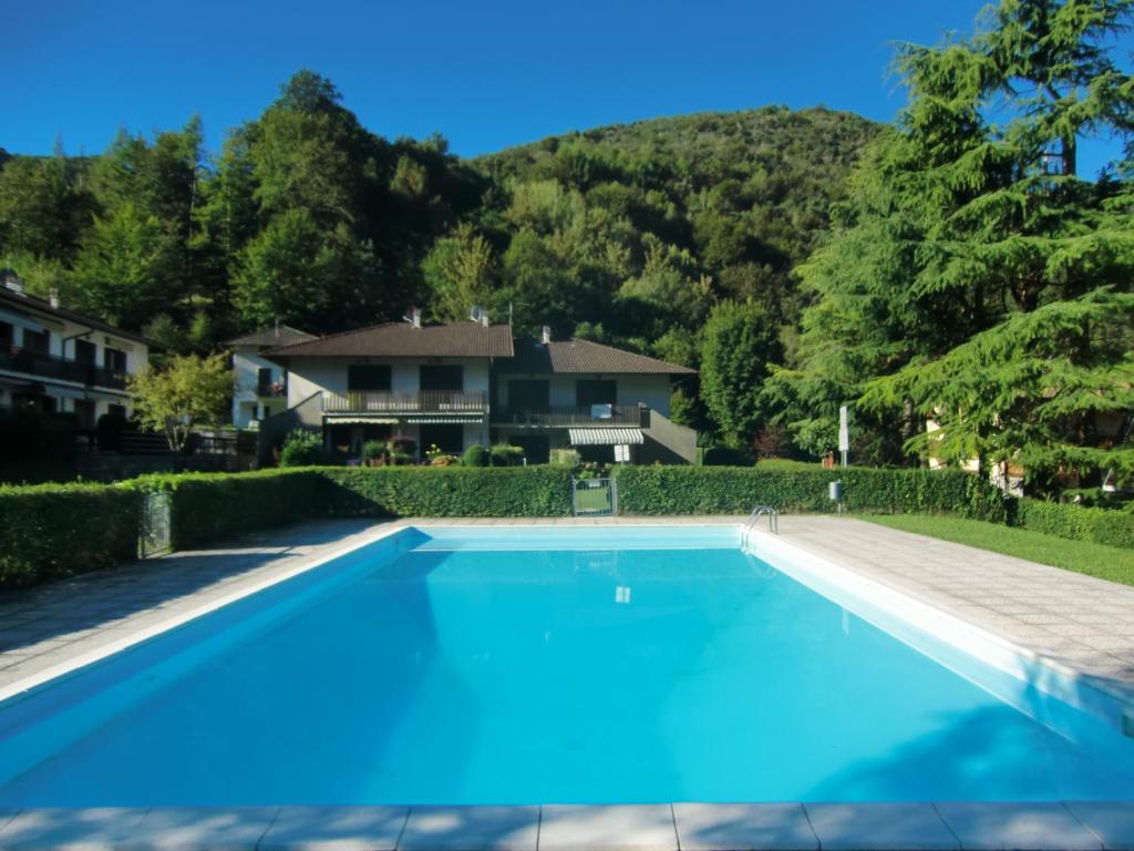 una piscina blu di fronte a una casa di Appartamento Belvedere a Molina di Ledro