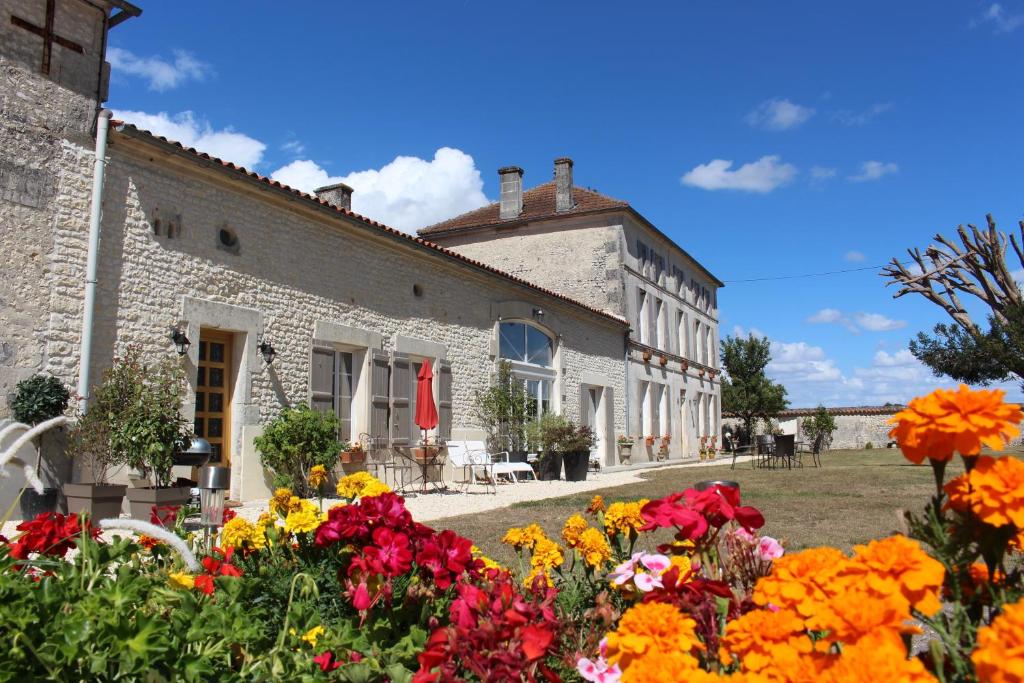 a building with flowers in front of it at Logis de L'Arceau in Celles