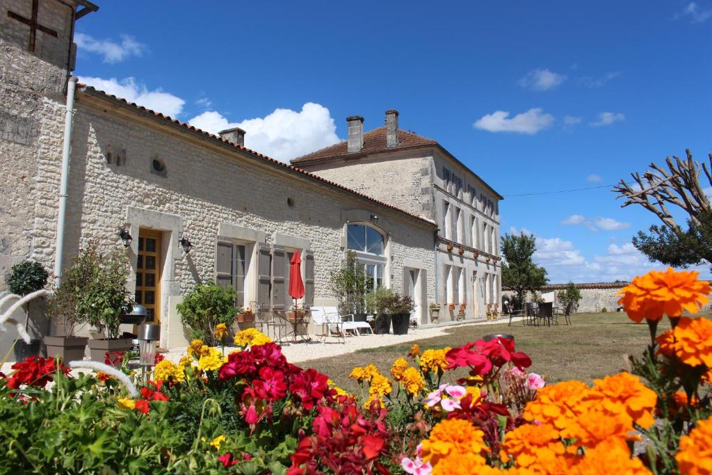 un bâtiment avec des fleurs devant lui dans l'établissement Logis de L'Arceau, à Celles