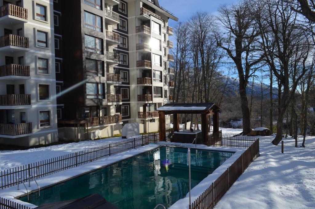 a swimming pool in the snow in front of a building at Departamento Termas de Chillan in Nevados de Chillan