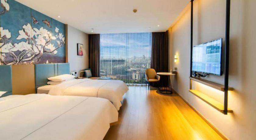 Postel nebo postele na pokoji v ubytování Magnotel Tongxiang Shimao Center