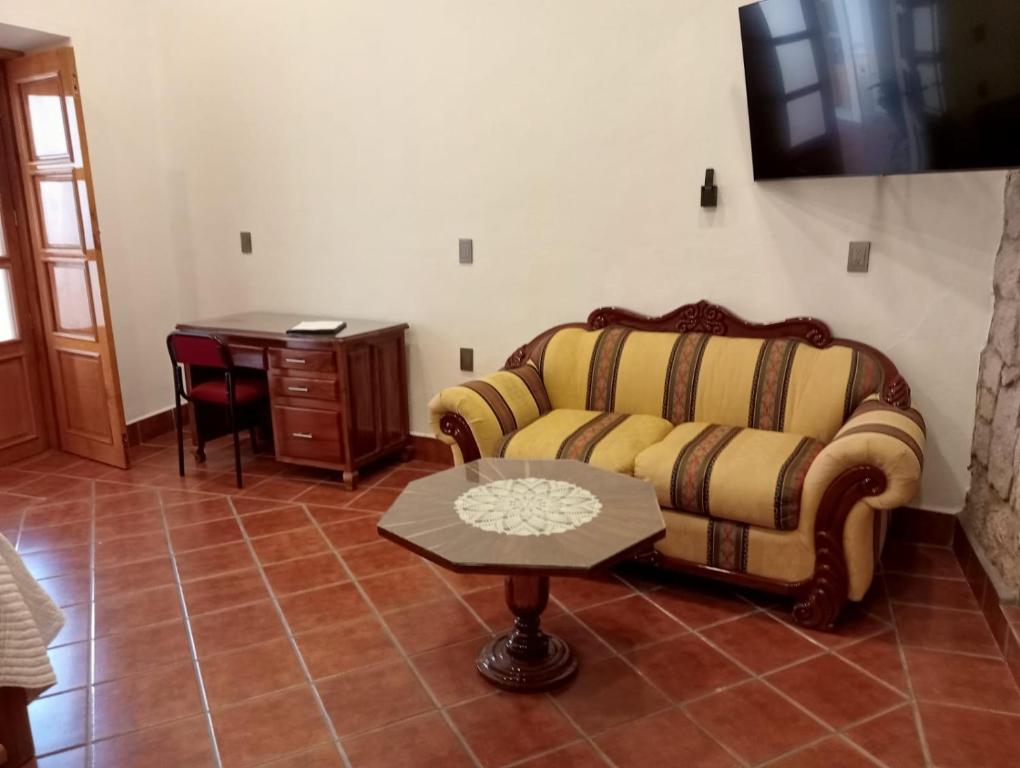 ein Wohnzimmer mit Sofa und Tisch in der Unterkunft Casa Purépecha, Habitación Itzi in Morelia
