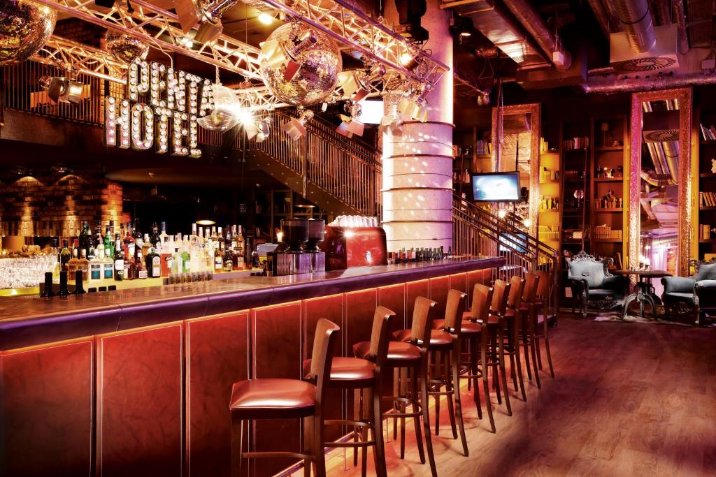 a bar with a bunch of stools in a room at pentahotel Vienna in Vienna