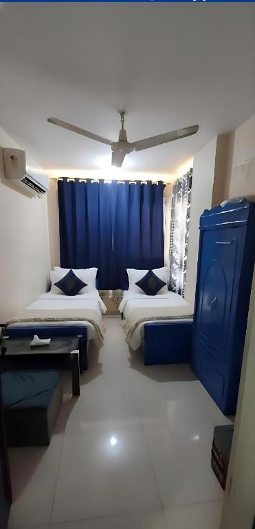 a room with two beds and a blue curtain at Sun Aswan inn in Aswan