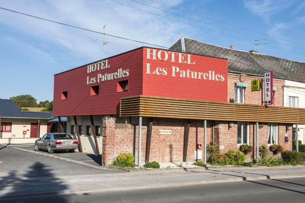 a hotel las palmas building on the corner of a street at LOGIS Hôtel - Les Paturelles in Avesnelles