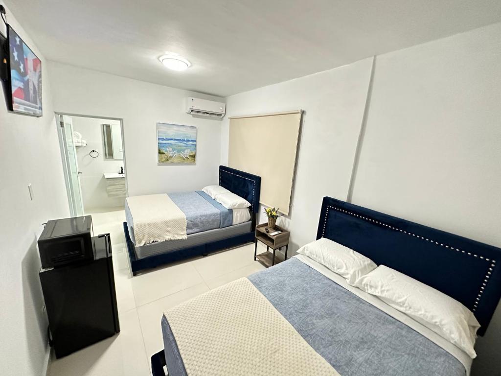 圣胡安Kantares Guest a 4 min Aeropuerto的一间有两张床和一面镜子的小卧室