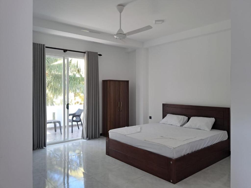 Fortress Holiday Apartments في هيكادوا: غرفة نوم بها سرير وباب زجاجي منزلق