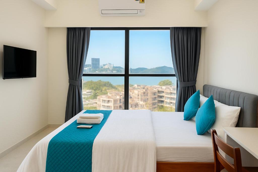 a bedroom with a bed with a large window at UrbanNest Service Apartments Powai in Mumbai