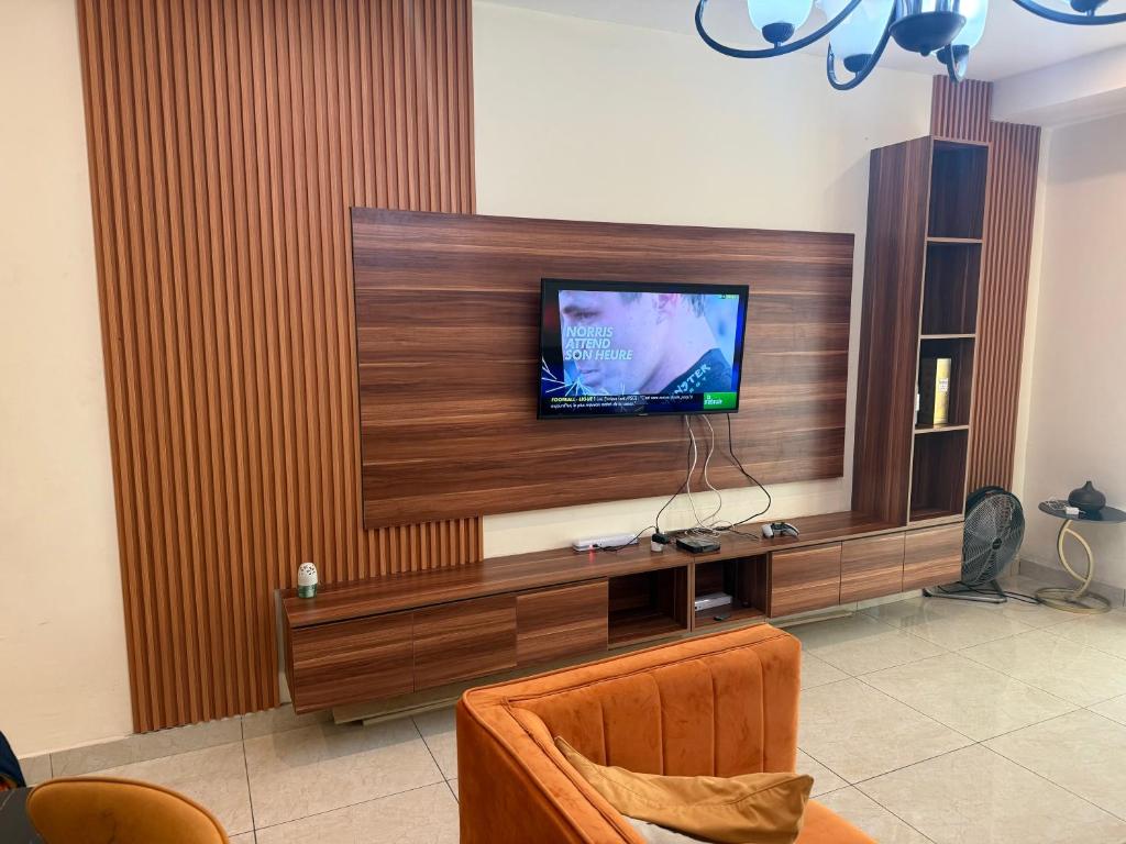 un soggiorno con una TV a schermo piatto su una parete di Appartement chic et moderne wifi Starlink a Douala