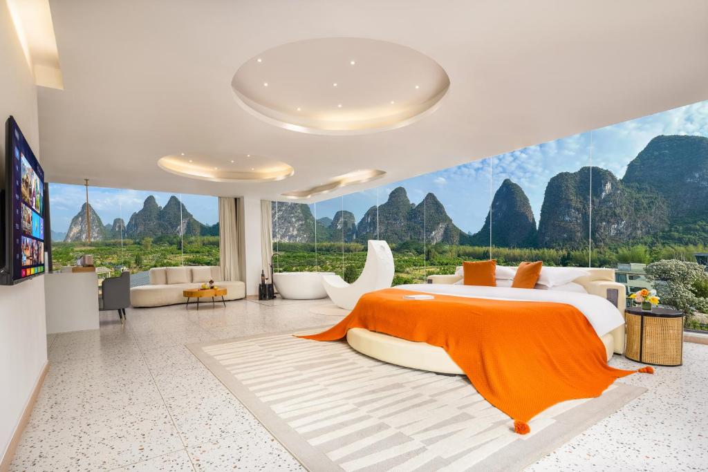 a bedroom with a bed with a view of mountains at Yangshuo Yundu Panoramic Luxury Hotel in Xingping