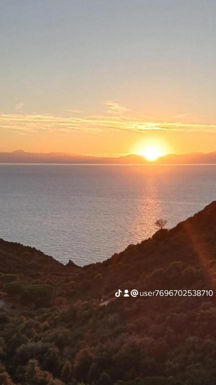 a sunset over the ocean with the sun setting at Sunset House in Mortigliano