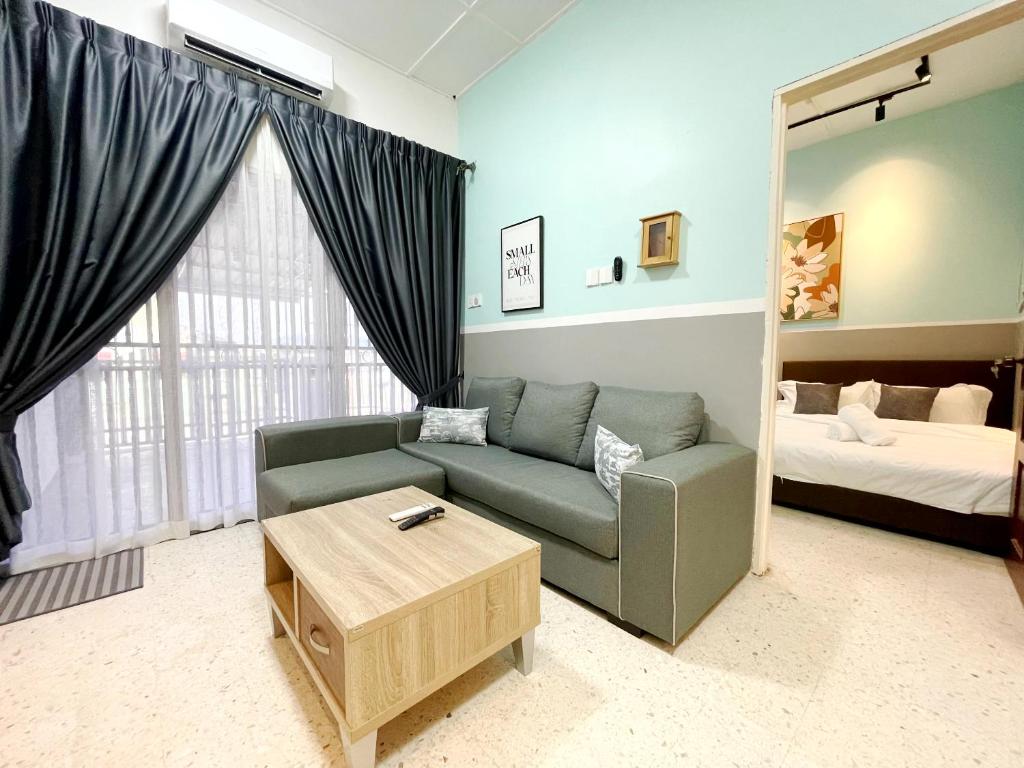 #SP Cozy&Warm 3Bedroom HomeStay 10PAX by S&T Homez في سِريمبان: غرفة معيشة مع أريكة وسرير