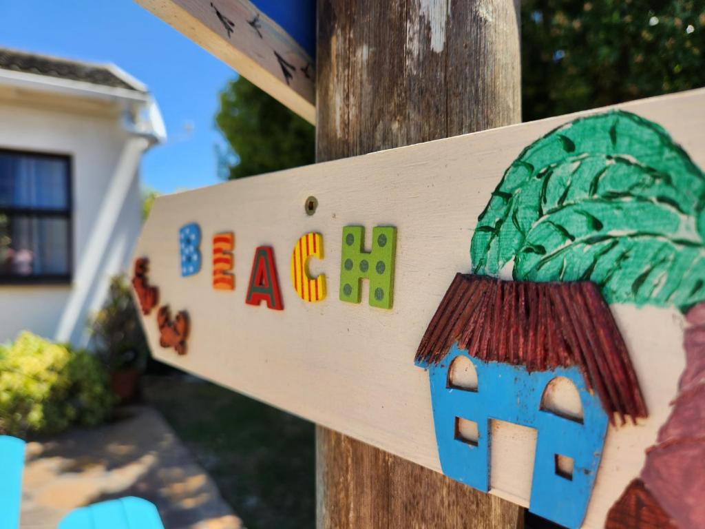 a sign for a house with a tree at Alcyone in Gqeberha