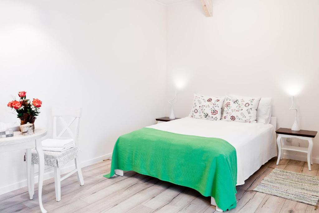 ウクタにあるRezydencja Pod Taborskimi Sosnamiのベッドルーム(白いベッド、緑の毛布付)