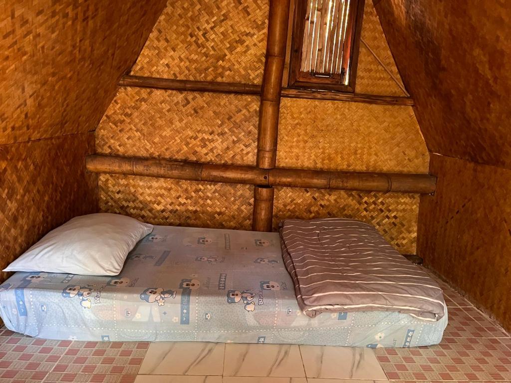 a bed in a small room with a window at sleepy hut in Pai