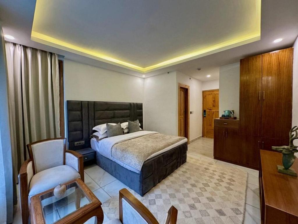 Un dormitorio con una cama, un escritorio y una silla. en Ausnya Tirthan, en Banjār