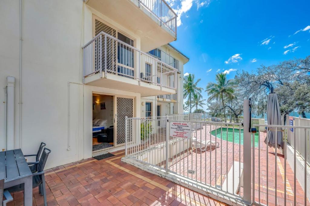 een huis met een balkon en een patio bij Shoreline Apartments - Unit 9b in Bargara