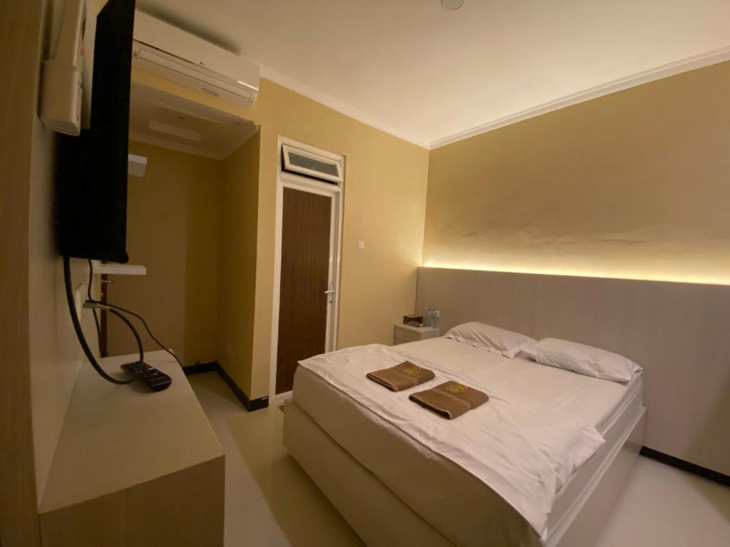 Una cama o camas en una habitación de Omah Joglo Bugis Guest House Syariah Cafe & Resto