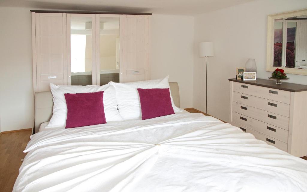 sypialnia z dużym białym łóżkiem z czerwonymi poduszkami w obiekcie Apartment-Joanneum w Grazu