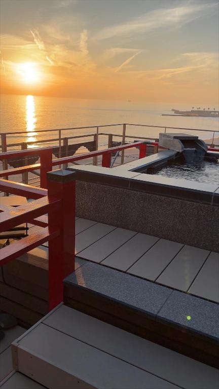 a boat on the water with the sunset in the background at 18歳以上の宿 澄江知多 in Utsumi