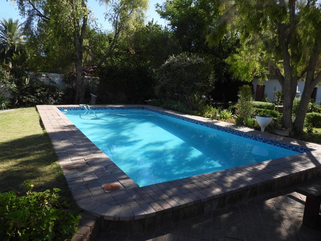 a swimming pool in a yard at Mountain Zebra Cottage in Graaff-Reinet