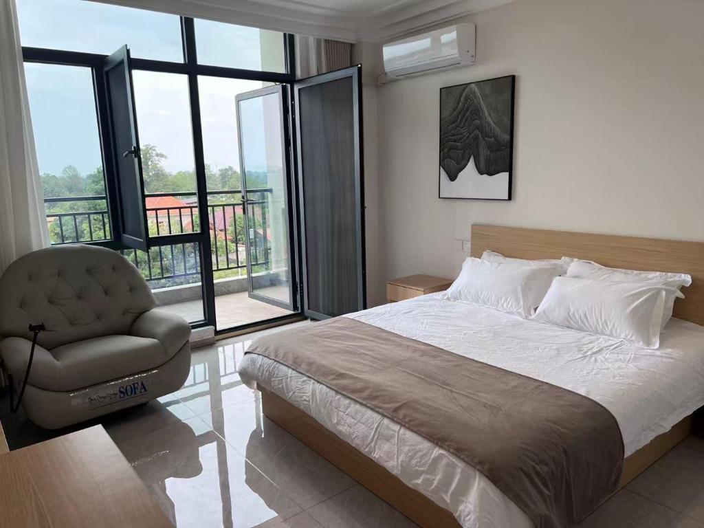 um quarto com uma cama, uma cadeira e janelas em Beijing Daxing Apartment em Ban Doung