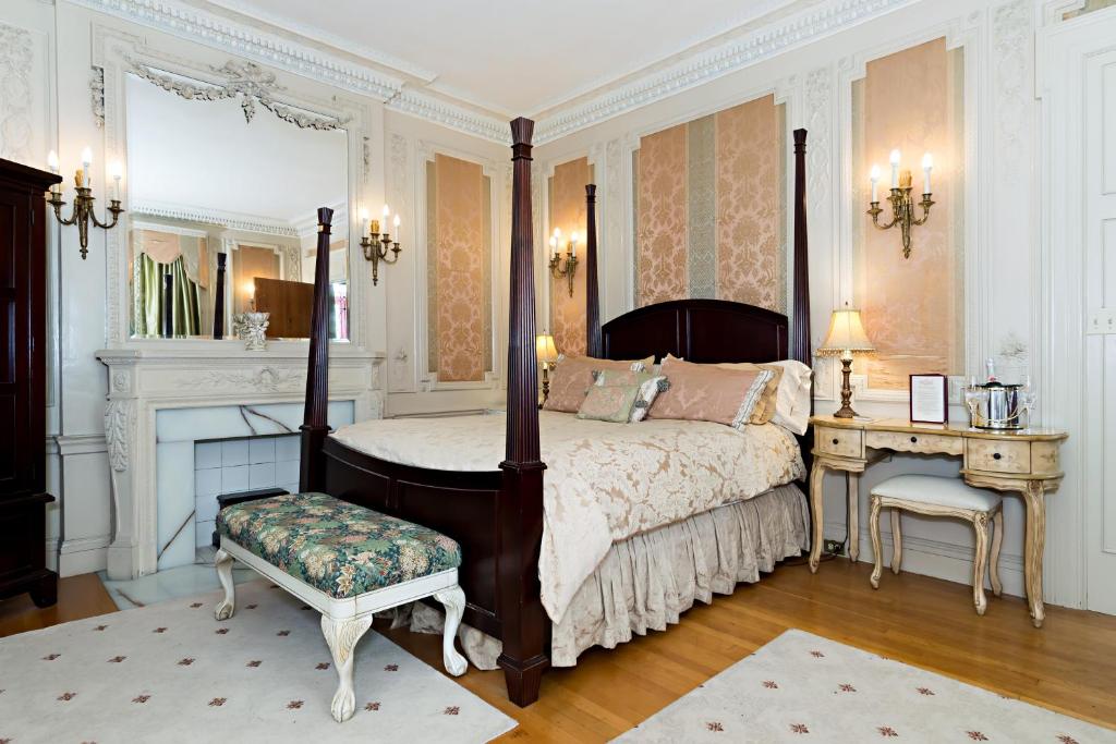 - une chambre avec un lit à baldaquin, un bureau et un lit sidx sidx sidx dans l'établissement Silver Fountain Inn, à Dover