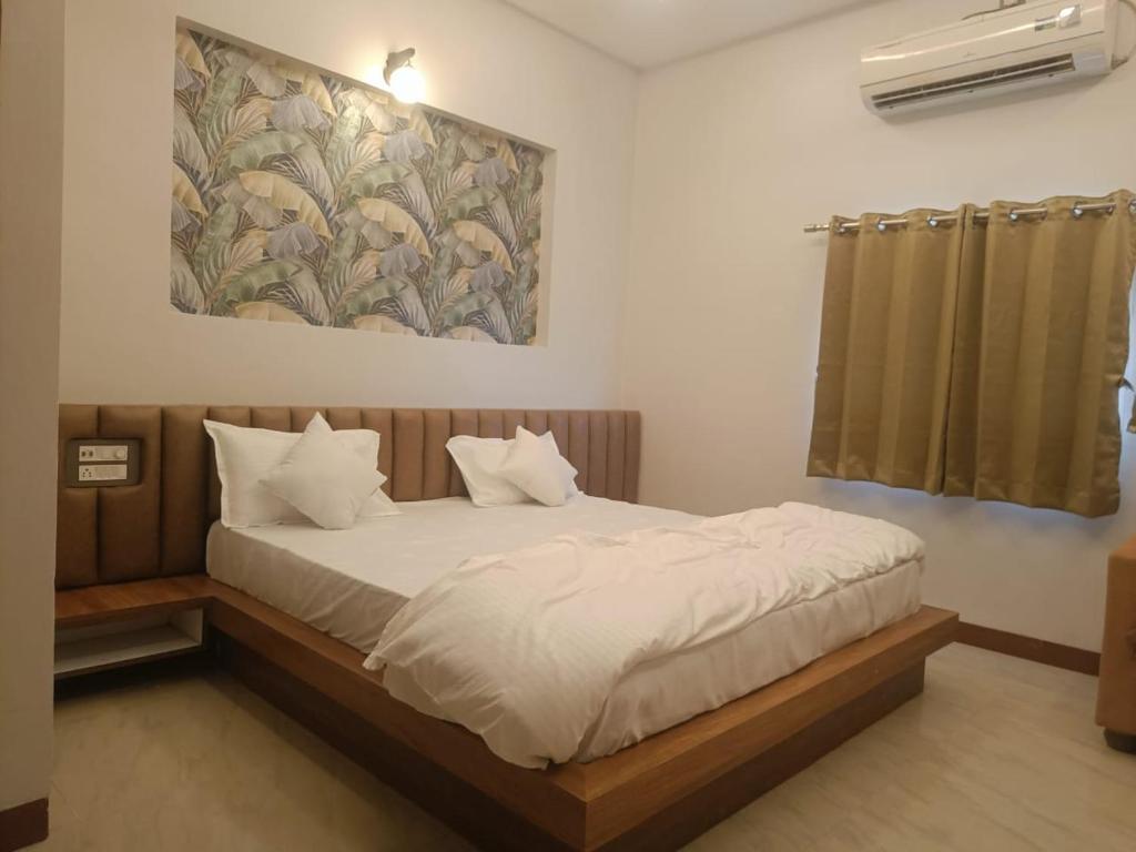 a bedroom with a bed and a painting on the wall at Moon palace in Maheshwar