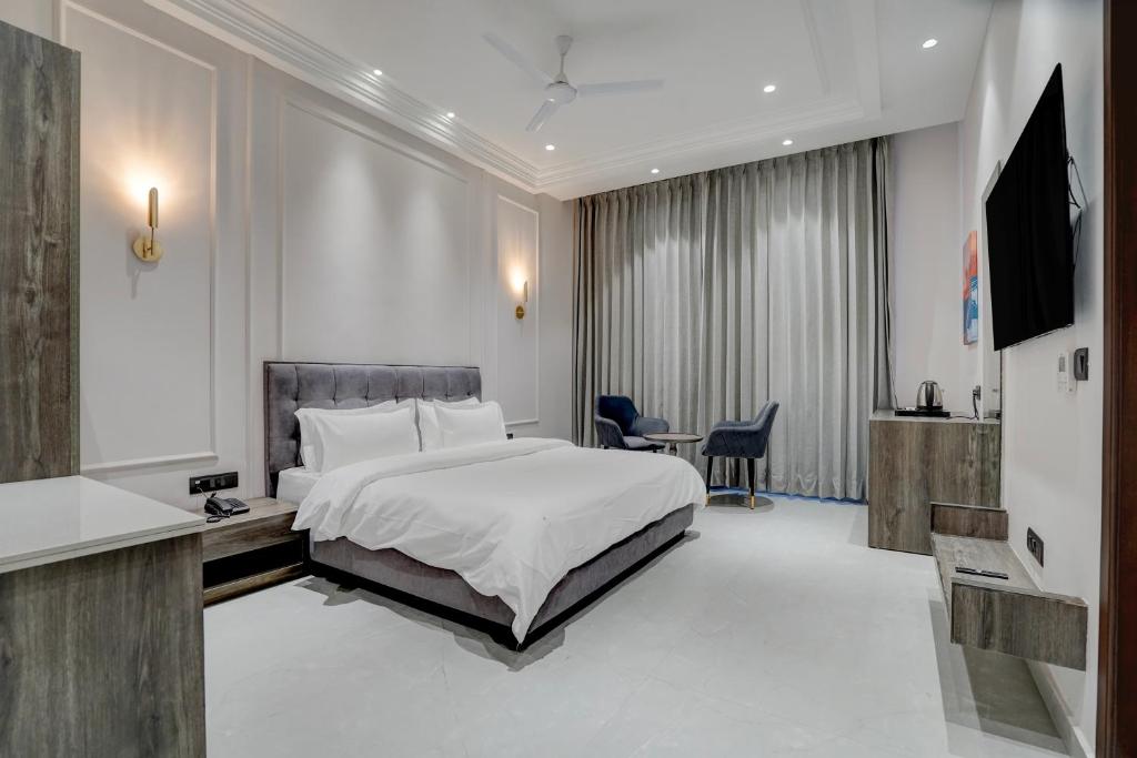 a bedroom with a bed and a desk and a television at Nirvana Hotel & Banquet in Batāla