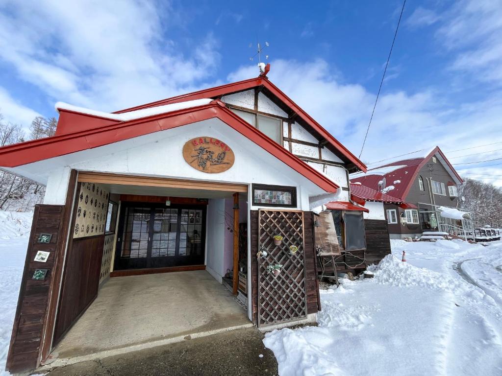 a building with a gate in the snow at Natsumi no Sato in Biei