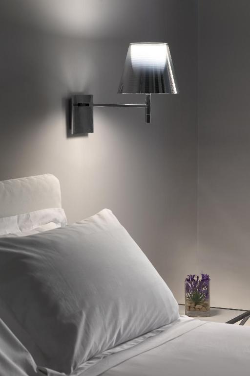 a bedroom with a white bed with a light above it at La Suite Boutique Hotel in Procida