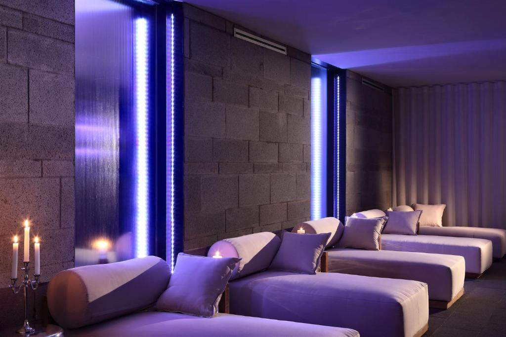a row of couches in a room with blue lights at La Suite Boutique Hotel in Procida