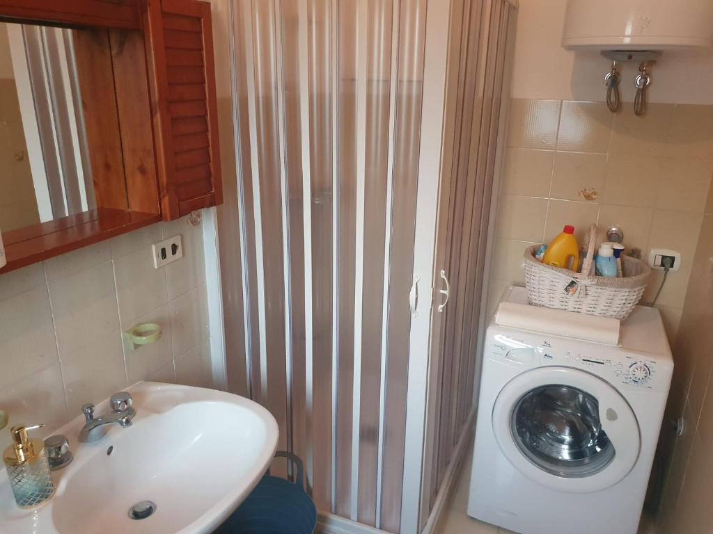 a bathroom with a washing machine and a sink at Masseria Marotta Appartamento in Santa Paolina