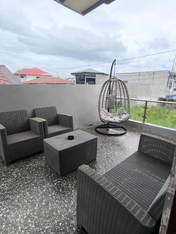 a patio with chairs and a swing on a balcony at Villa Maria 1 in Bacolod