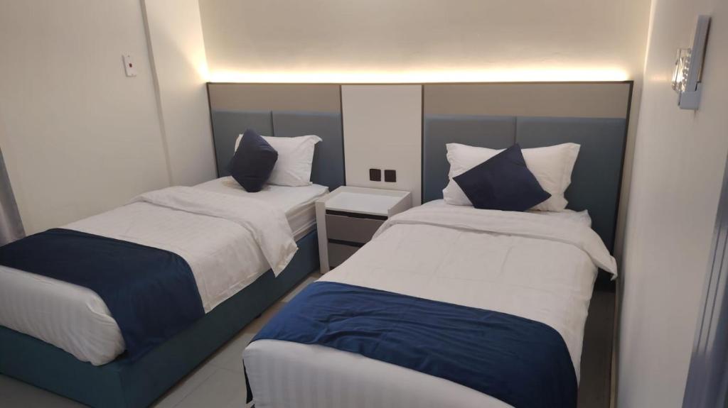two beds in a small room with two at شقق راما الشرق المخدومة المملكة العربية السعودية حي الشفاء حائل in Hail