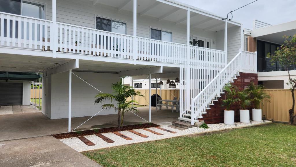 a house with a white staircase in a yard at Beach Bound-Jervis Bay in Vincentia