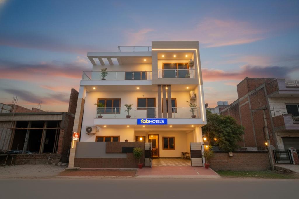 a white building with a sign in front of it at FabHotel Anant Inn in Lucknow