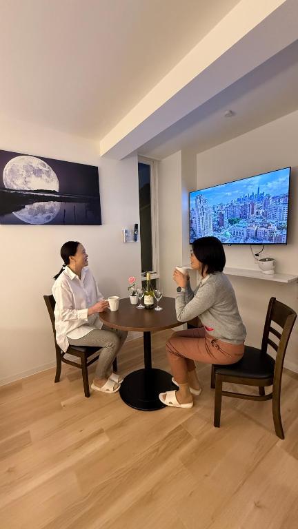three women sitting around a table in a room at Moon Base Tokyo Inn in Tokyo