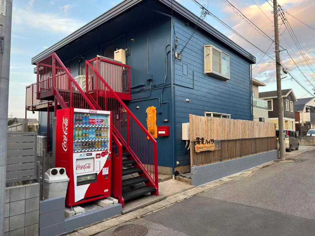 a blue building with a red stair case on it at 旅人の家 日式民宿 丸々貸切 JR線 常磐線南柏駅 キッチン 調理器具 洗濯機 生活必需品付 高速WiFi上野駅まで30分 in Kashiwa