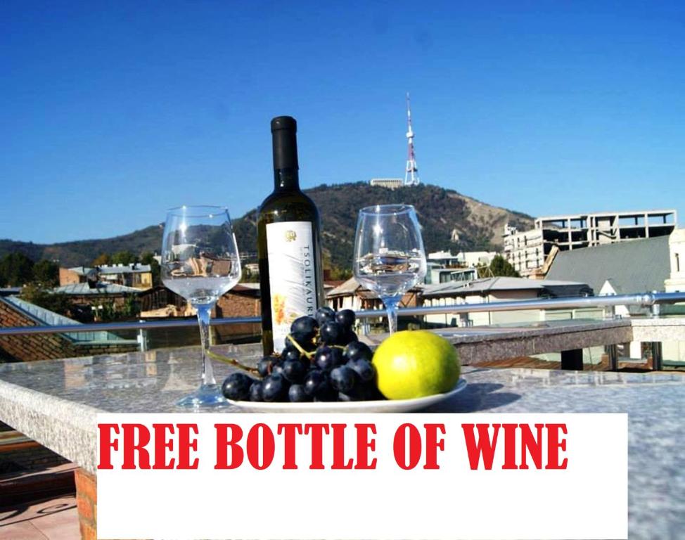 a bottle of wine and two wine glasses on a table at Tbiliseli Inn in Tbilisi City