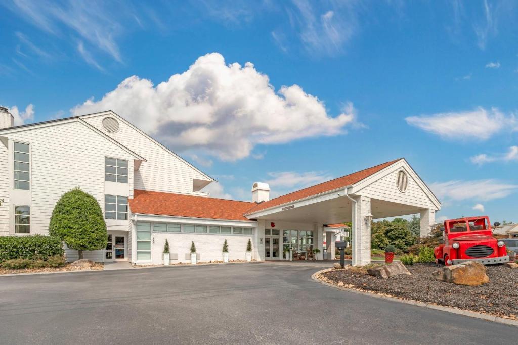 a large white building with a red truck in the driveway at The Inn at Apple Valley, an Ascend Collection Hotel in Pigeon Forge