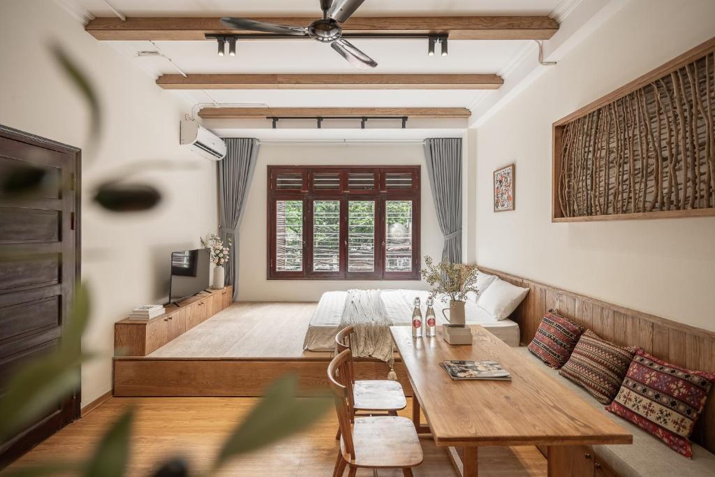 a living room with a wooden table and a couch at Urban Horizon Boutique Suites in Hanoi