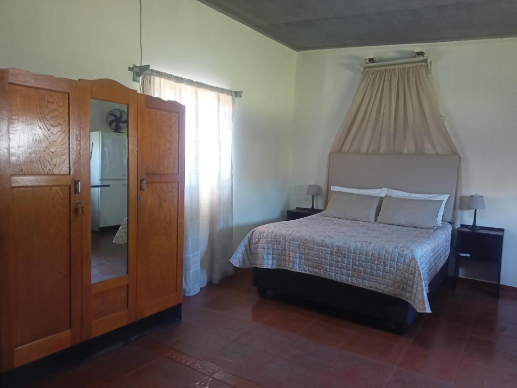 een slaapkamer met een bed en een groot raam bij Mooi Uitsig Droom in Beaufort West